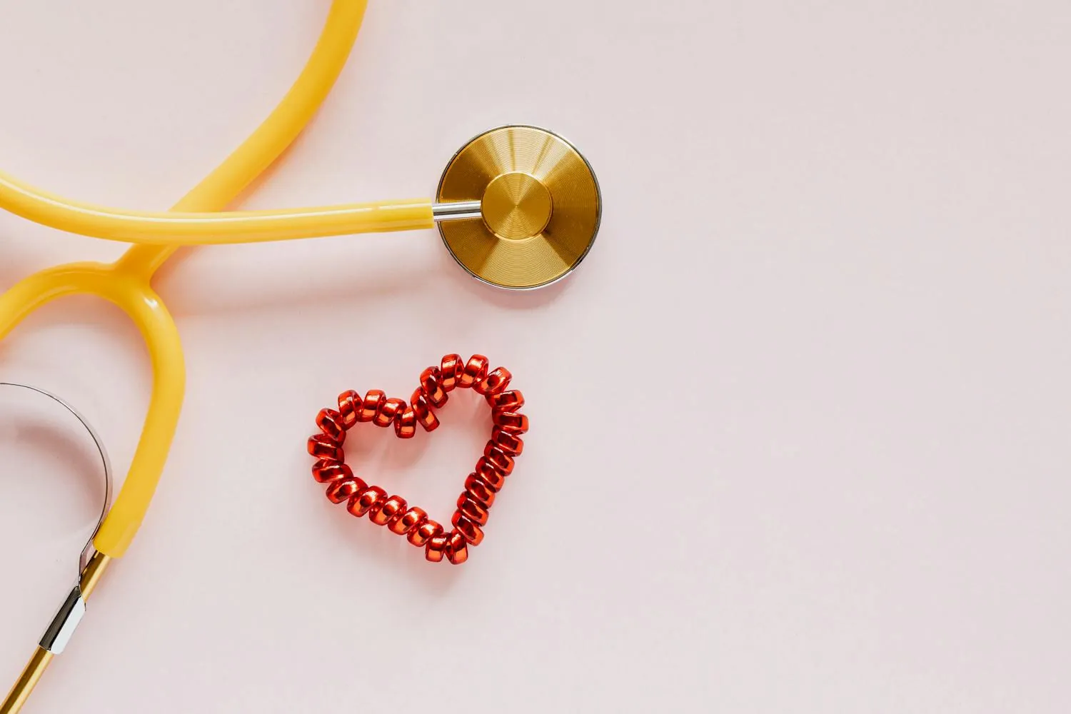 A stethoscope beside a red heart shape, representing cardiovascular and cholesterol care